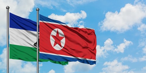 Lesotho and North Korea flag waving in the wind against white cloudy blue sky together. Diplomacy concept, international relations.