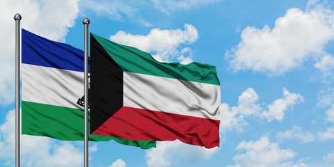Lesotho and Kuwait flag waving in the wind against white cloudy blue sky together. Diplomacy concept, international relations.