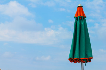 closed umbrella on the beach with sky in the background. La spezia, Italy