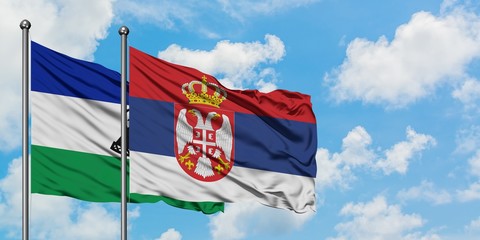 Lesotho and Serbia flag waving in the wind against white cloudy blue sky together. Diplomacy concept, international relations.