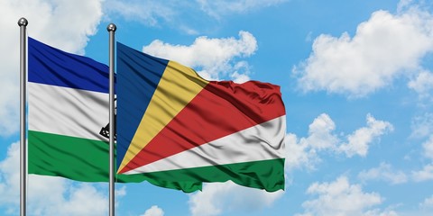 Lesotho and Seychelles flag waving in the wind against white cloudy blue sky together. Diplomacy concept, international relations.