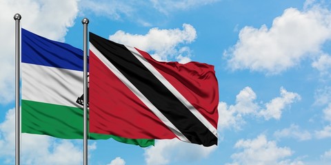Lesotho and Trinidad And Tobago flag waving in the wind against white cloudy blue sky together. Diplomacy concept, international relations.
