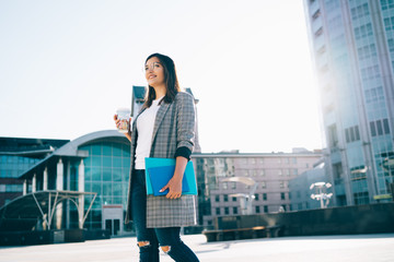 Funny hipster girl in spectacles for vision correction walking on urban setting and enjoying time...