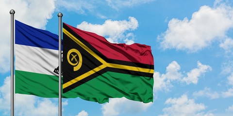 Lesotho and Vanuatu flag waving in the wind against white cloudy blue sky together. Diplomacy concept, international relations.