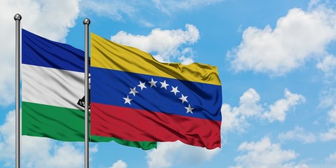 Lesotho and Venezuela flag waving in the wind against white cloudy blue sky together. Diplomacy concept, international relations.