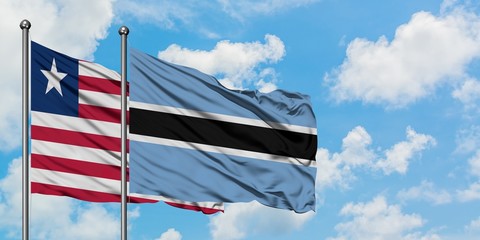 Liberia and Botswana flag waving in the wind against white cloudy blue sky together. Diplomacy concept, international relations.