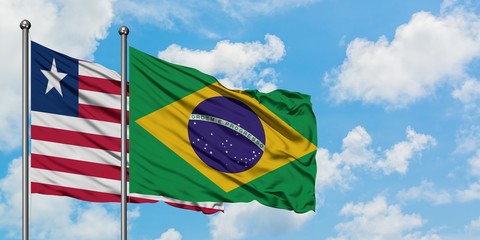 Liberia and Brazil flag waving in the wind against white cloudy blue sky together. Diplomacy concept, international relations.