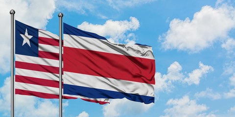 Liberia and Costa Rica flag waving in the wind against white cloudy blue sky together. Diplomacy concept, international relations.