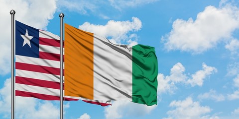Liberia and Cote D'Ivoire flag waving in the wind against white cloudy blue sky together. Diplomacy concept, international relations.