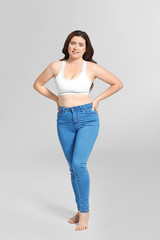 Young body positive woman on grey background