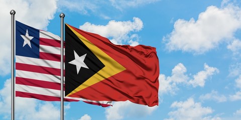 Liberia and East Timor flag waving in the wind against white cloudy blue sky together. Diplomacy concept, international relations.