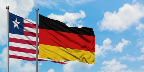 Liberia and Germany flag waving in the wind against white cloudy blue sky together. Diplomacy concept, international relations.