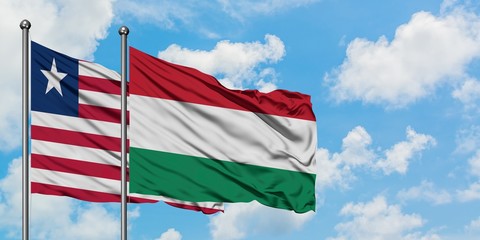 Liberia and Hungary flag waving in the wind against white cloudy blue sky together. Diplomacy concept, international relations.