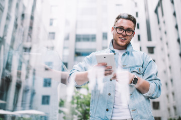 Smiling man with tablet on street