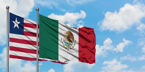 Liberia and Mexico flag waving in the wind against white cloudy blue sky together. Diplomacy concept, international relations.