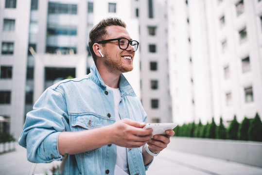 Happy Man In Earbuds On Street