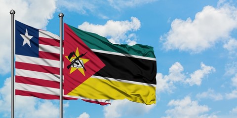Liberia and Mozambique flag waving in the wind against white cloudy blue sky together. Diplomacy concept, international relations.