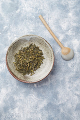 Dried Green Tea Leaves on Bright Background. Top view. Close up. Copy space.