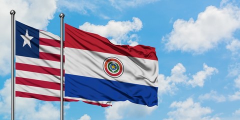 Liberia and Paraguay flag waving in the wind against white cloudy blue sky together. Diplomacy concept, international relations.
