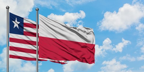 Liberia and Poland flag waving in the wind against white cloudy blue sky together. Diplomacy concept, international relations.