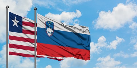 Liberia and Slovenia flag waving in the wind against white cloudy blue sky together. Diplomacy concept, international relations.