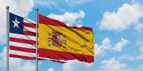 Liberia and Spain flag waving in the wind against white cloudy blue sky together. Diplomacy concept, international relations.