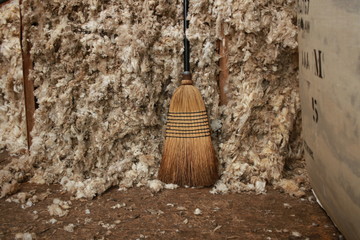 piles of freshly shorn wool swept into bays waiting to be bagged into bales for selling on a small family farm in rural Victoria, Australia