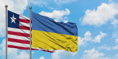 Liberia and Ukraine flag waving in the wind against white cloudy blue sky together. Diplomacy concept, international relations.