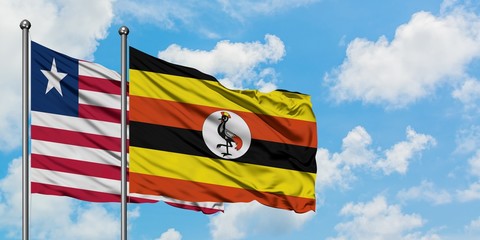 Liberia and Uganda flag waving in the wind against white cloudy blue sky together. Diplomacy concept, international relations.