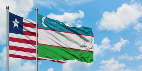 Liberia and Uzbekistan flag waving in the wind against white cloudy blue sky together. Diplomacy concept, international relations.