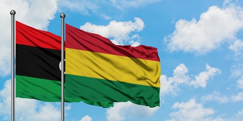 Libya and Bolivia flag waving in the wind against white cloudy blue sky together. Diplomacy concept, international relations.