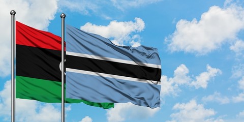 Libya and Botswana flag waving in the wind against white cloudy blue sky together. Diplomacy concept, international relations.