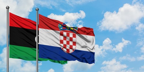 Libya and Croatia flag waving in the wind against white cloudy blue sky together. Diplomacy concept, international relations.