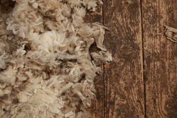 piles of freshly shorn wool scattered on the timber floor of the family farm woolshed shearing shed, rural Victoria, Australia