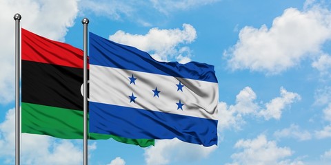 Libya and Honduras flag waving in the wind against white cloudy blue sky together. Diplomacy concept, international relations.