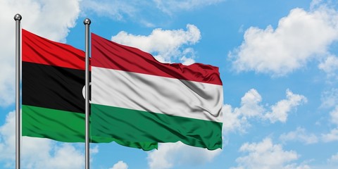 Fototapeta na wymiar Libya and Hungary flag waving in the wind against white cloudy blue sky together. Diplomacy concept, international relations.