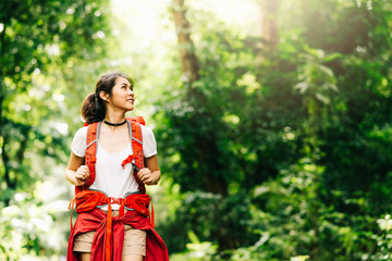 woman traveler with backpack walking in forest