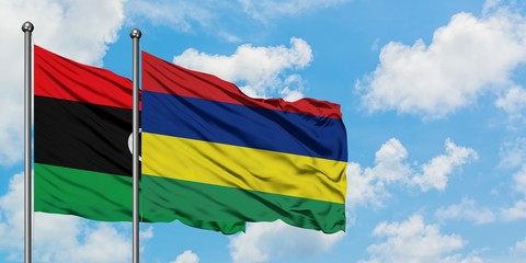 Libya and Mauritius flag waving in the wind against white cloudy blue sky together. Diplomacy concept, international relations.