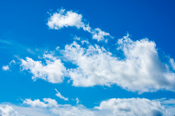 Obraz na płótnie Canvas Sunny dramatic fluffy clouds against a blue summer sky