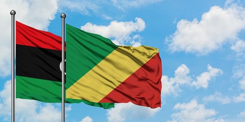 Libya and Republic Of The Congo flag waving in the wind against white cloudy blue sky together. Diplomacy concept, international relations.