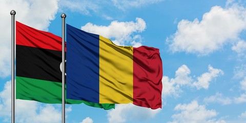 Libya and Romania flag waving in the wind against white cloudy blue sky together. Diplomacy concept, international relations.