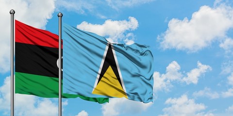 Libya and Saint Lucia flag waving in the wind against white cloudy blue sky together. Diplomacy concept, international relations.