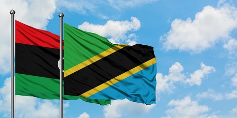 Libya and Tanzania flag waving in the wind against white cloudy blue sky together. Diplomacy concept, international relations.