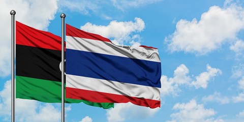 Libya and Thailand flag waving in the wind against white cloudy blue sky together. Diplomacy concept, international relations.