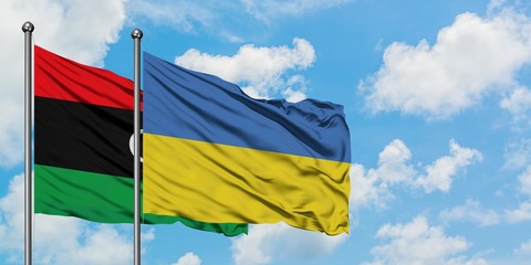Libya and Ukraine flag waving in the wind against white cloudy blue sky together. Diplomacy concept, international relations.