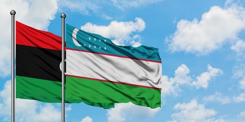 Libya and Uzbekistan flag waving in the wind against white cloudy blue sky together. Diplomacy concept, international relations.