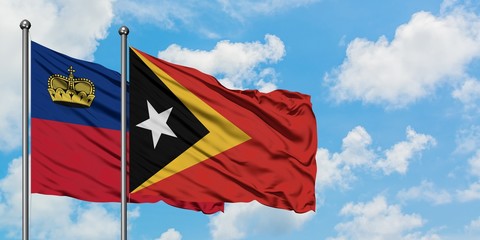 Liechtenstein and East Timor flag waving in the wind against white cloudy blue sky together. Diplomacy concept, international relations.