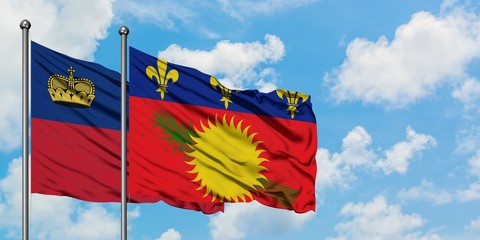 Liechtenstein and Guadeloupe flag waving in the wind against white cloudy blue sky together. Diplomacy concept, international relations.