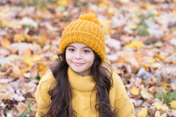 Lovely season. Keep warmest this autumn. Child in yellow hat outdoors. Autumn skin care routine. Kid wear warm knitted hat. Warm woolen accessory. Girl long hair happy face autumn nature background