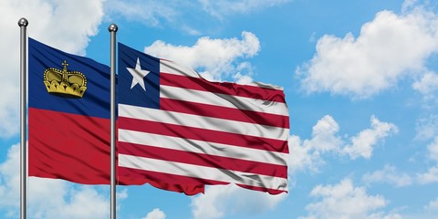 Liechtenstein and Liberia flag waving in the wind against white cloudy blue sky together. Diplomacy concept, international relations.